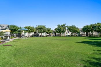 A large green lawn in front of a row of houses
